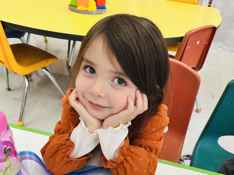 Girl in classroom raising hand