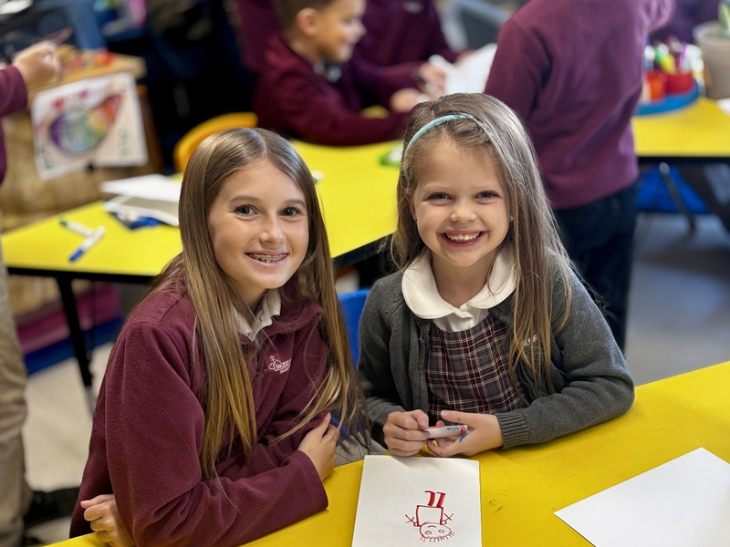 Girl in classroom raising hand